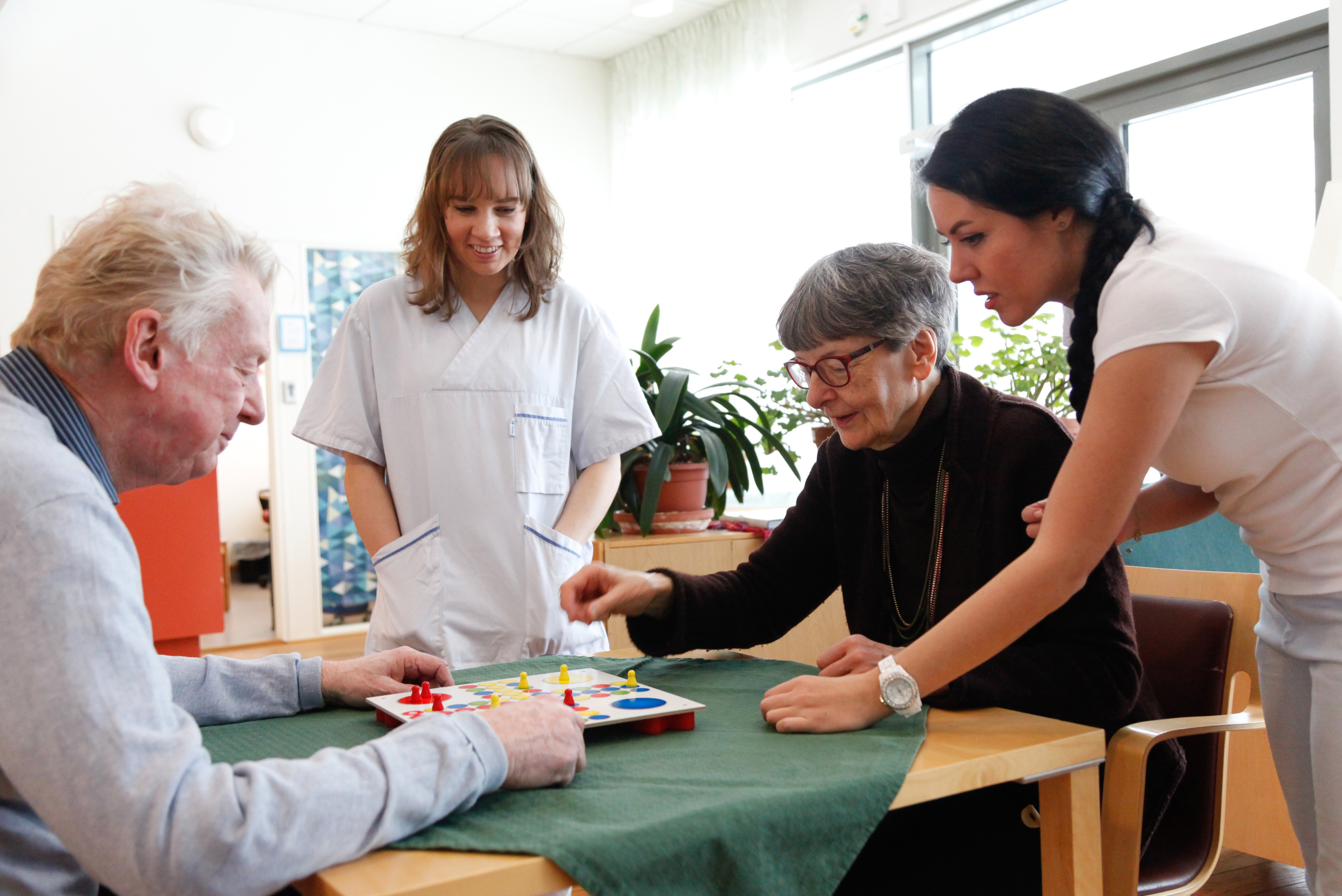 Äldre par som spelar Fia med knuff på ett äldreboende.