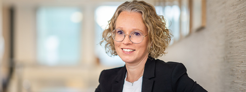 Photo of woman with blond curly hair in black jacket