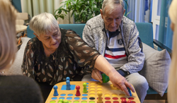 &Auml;ldre dam och herre spelar Fia med knuff ihop med personalen p&aring; &auml;ldreboendet.png
