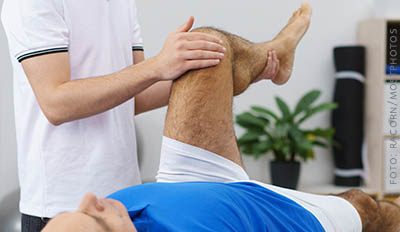 Fysioterapeut håller i patients knä