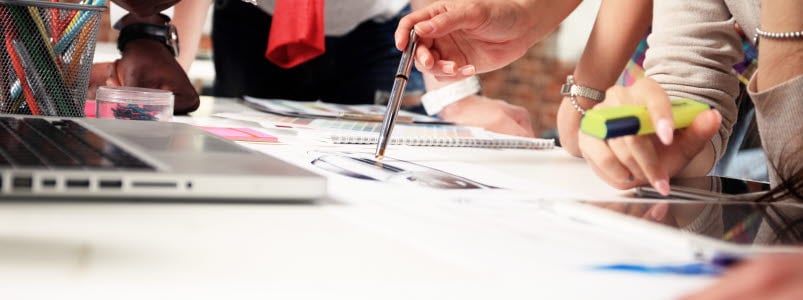 Personer, händer runt ett skrivbord