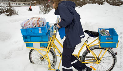 Brevbärare drar cykel genom snödriva