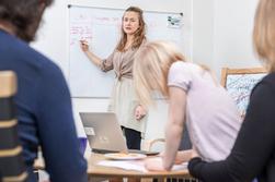 Socialsekreterare skriver på whiteboardtavla medan föräldrar lyssnar och 5-årig flicka ritar