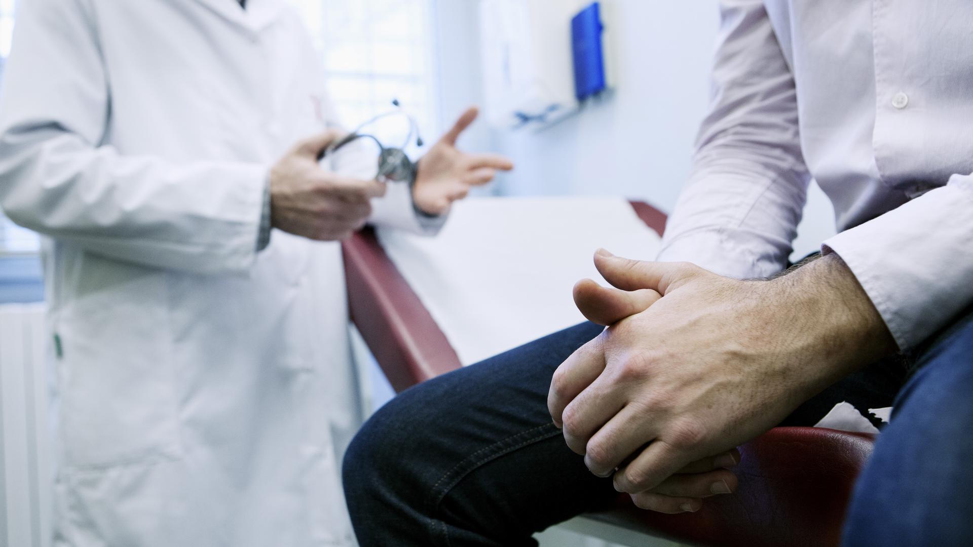 Man i konsultation med doktor