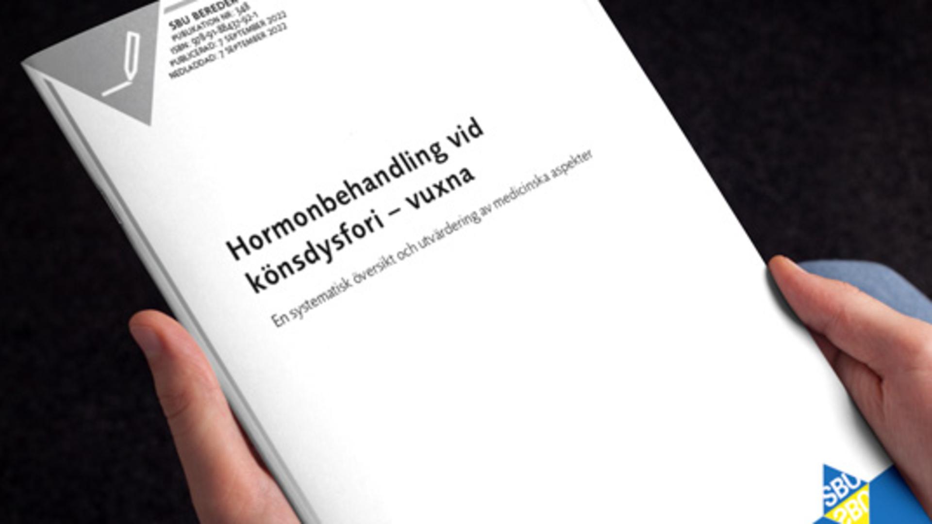 Man ser två händer som håller i en trycksak.