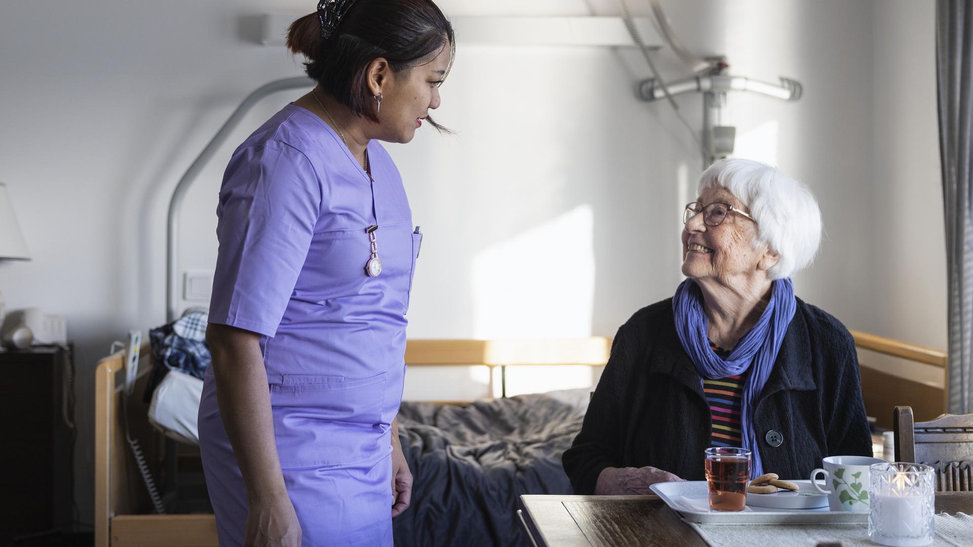 Sjukvårdpersonal som pratar med en patient/brukare.
