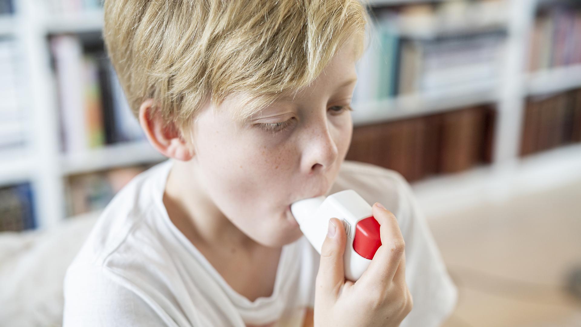 Pojke som inhalerar astmaspray
