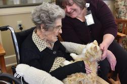 Victoria McNeill, coordinator of Nursing Activities works with resident June VanHorn, as she holds an animatronic cat. At the Highlands of Wyomissing in their Dementia care wing where patients are treated with music therapy sessions, touchscreens, and animatronic pets