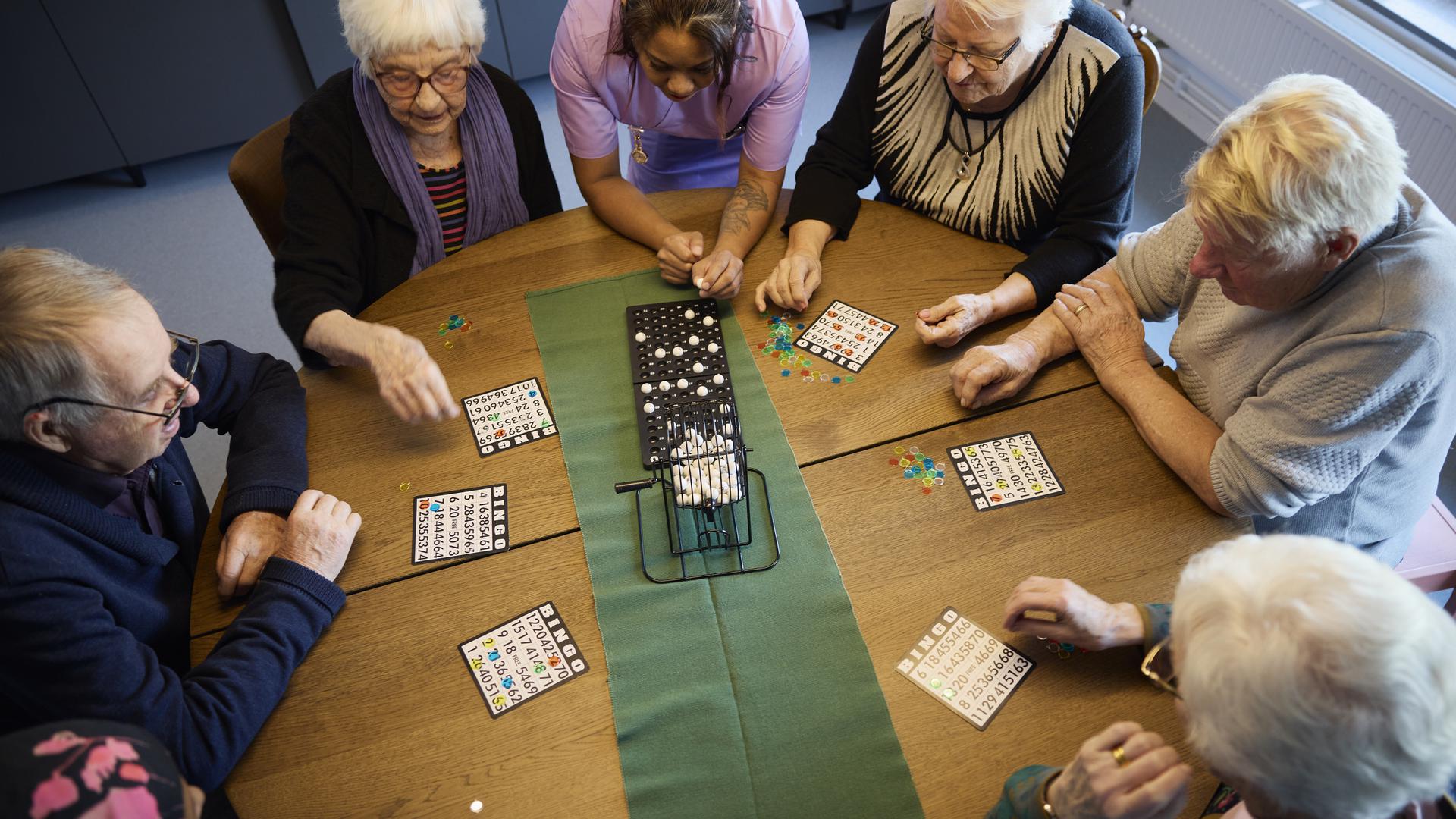 Boende och personal spelar bingo på äldreboende
