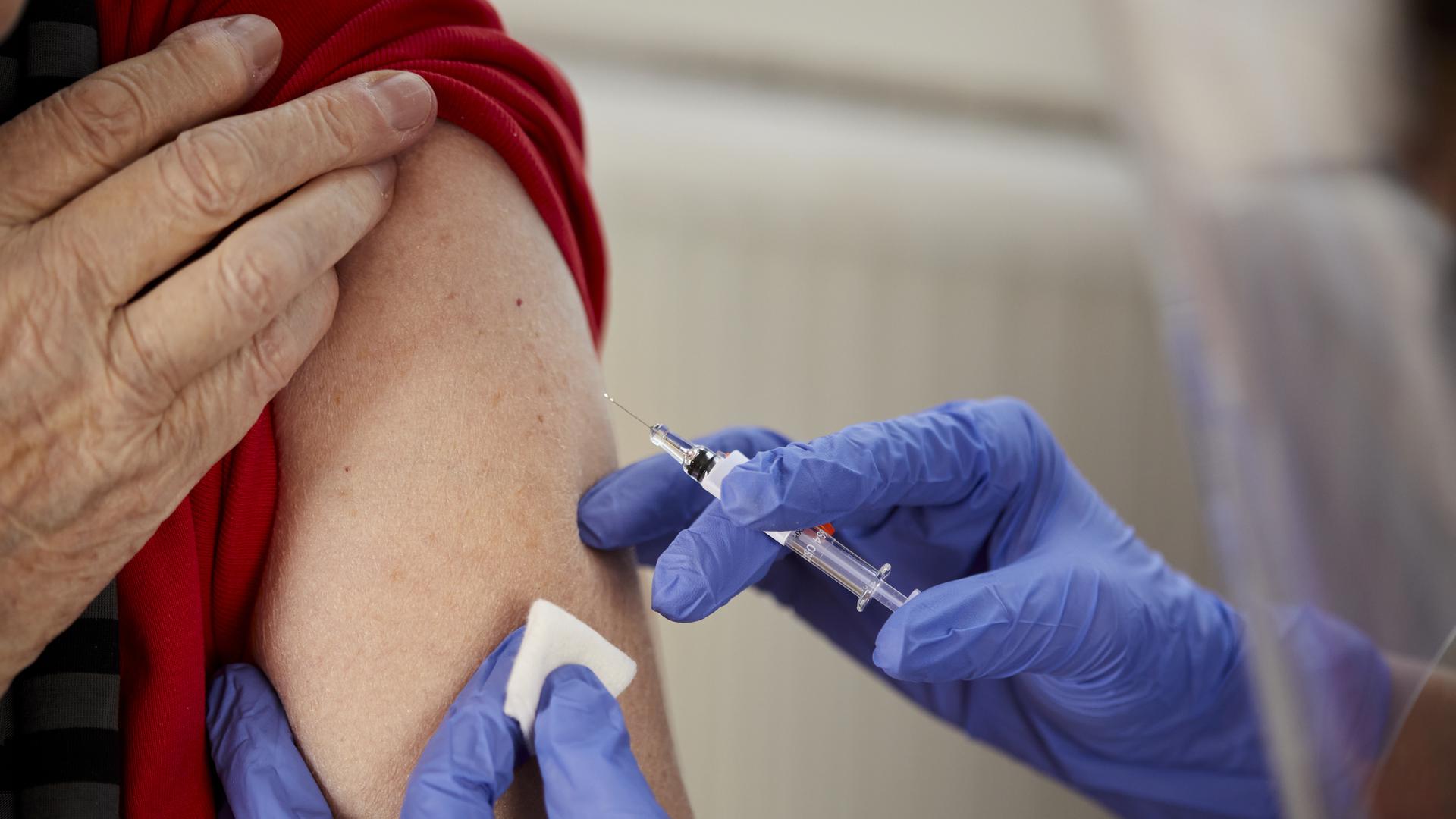 Äldre kvinna som blir vaccinerad