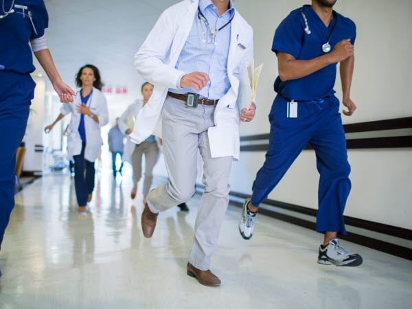 Läkare som springer i en sjukhuskorridor