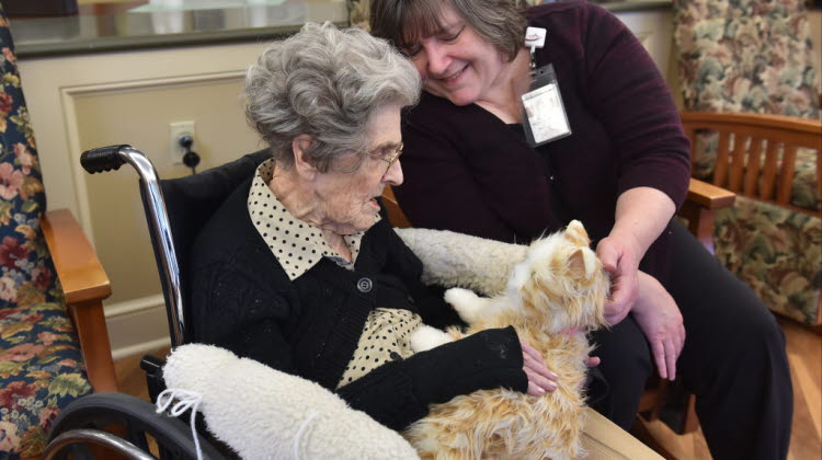 Victoria McNeill, coordinator of Nursing Activities works with resident June VanHorn, as she holds an animatronic cat. At the Highlands of Wyomissing in their Dementia care wing where patients are treated with music therapy sessions, touchscreens, and animatronic pets