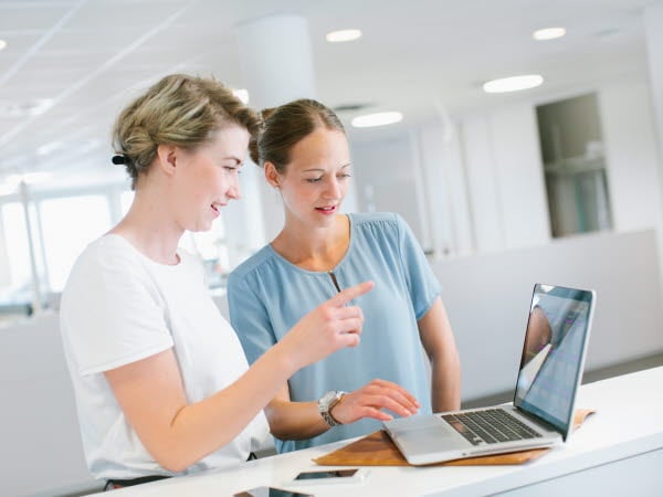 Kvinnor jobbar vid bärbar dator
