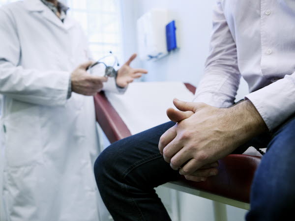 Man i konsultation med doktor