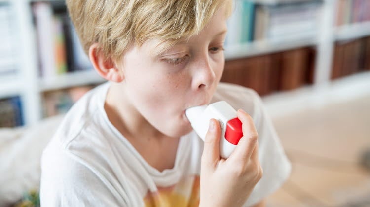 Pojke som inhalerar astmaspray