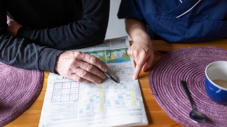 Kvinnlig hemtjänstpersonal hemma hos äldre man