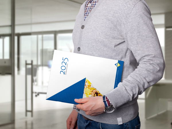 En person håller i årets årsredovisning från SBU