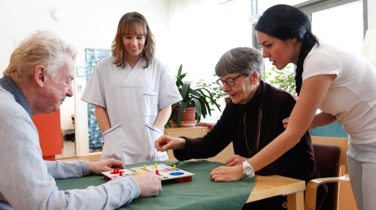 Äldre par som spelar Fia med knuff på ett äldreboende. 