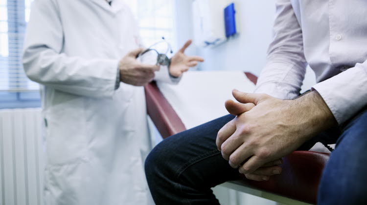 Man i konsultation med doktor
