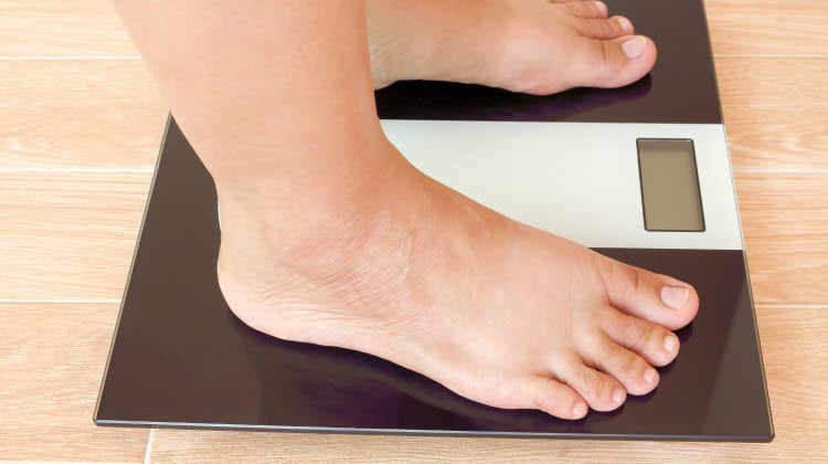 Närbild på ett par fötter som står på en våg