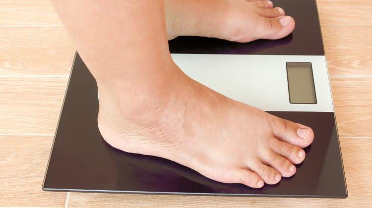 Närbild på ett par fötter som står på en våg