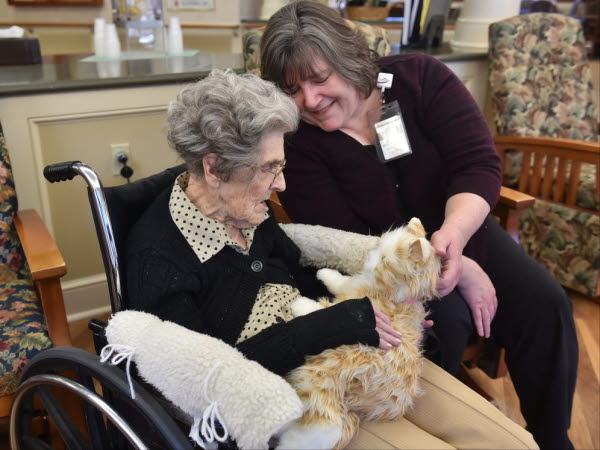 Victoria McNeill, coordinator of Nursing Activities works with resident June VanHorn, as she holds an animatronic cat. At the Highlands of Wyomissing in their Dementia care wing where patients are treated with music therapy sessions, touchscreens, and animatronic pets
