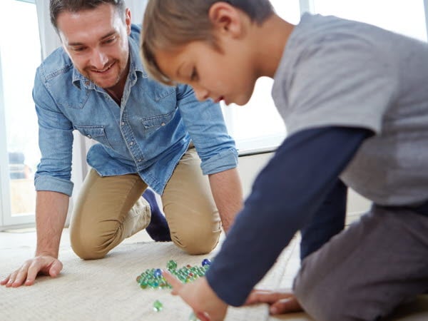 Far och son som spelar kula inomhus