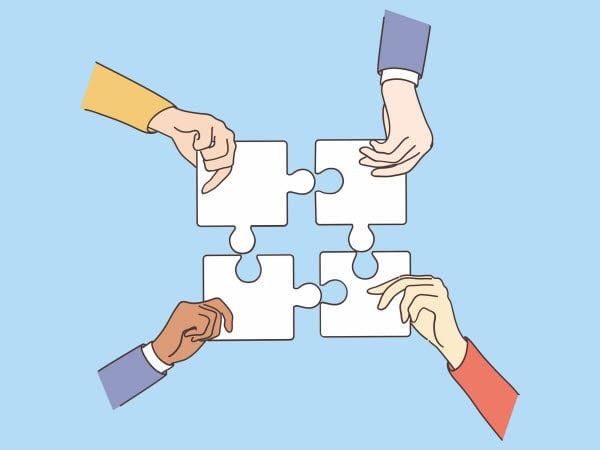 Fyra händer som håller ihop varsin pusselbit